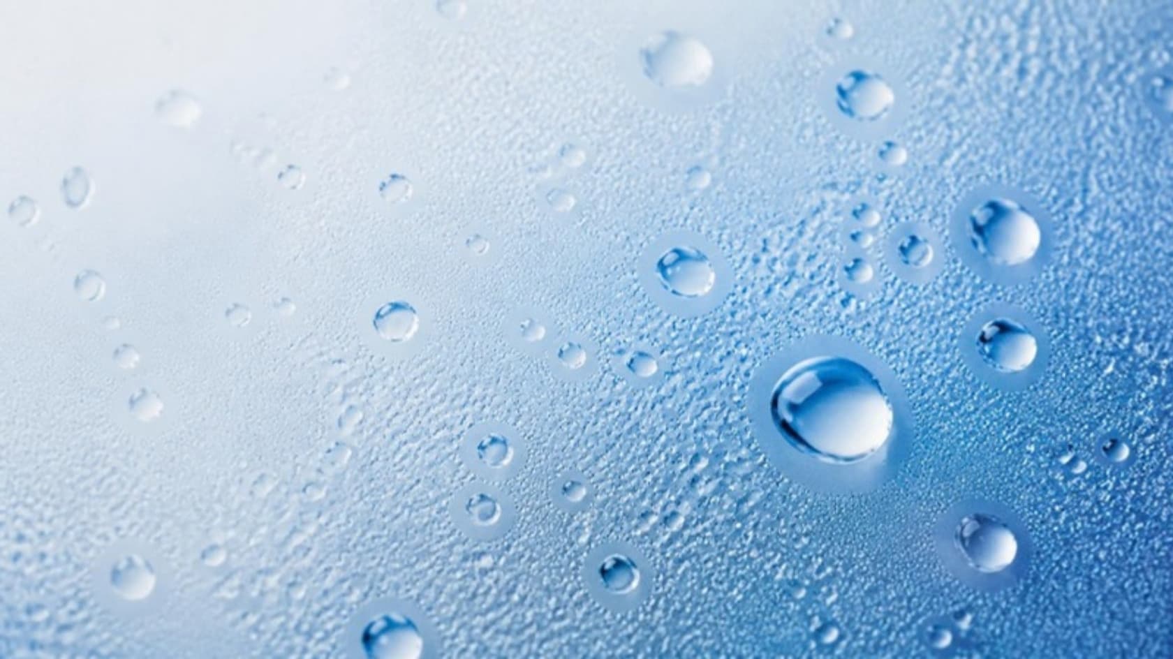 Beads of water on cool blue glass.