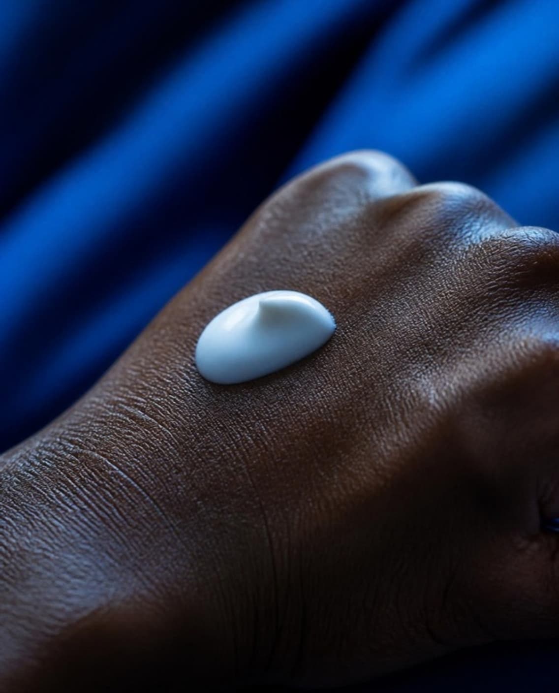 A dab of white cream on the back of a hand.